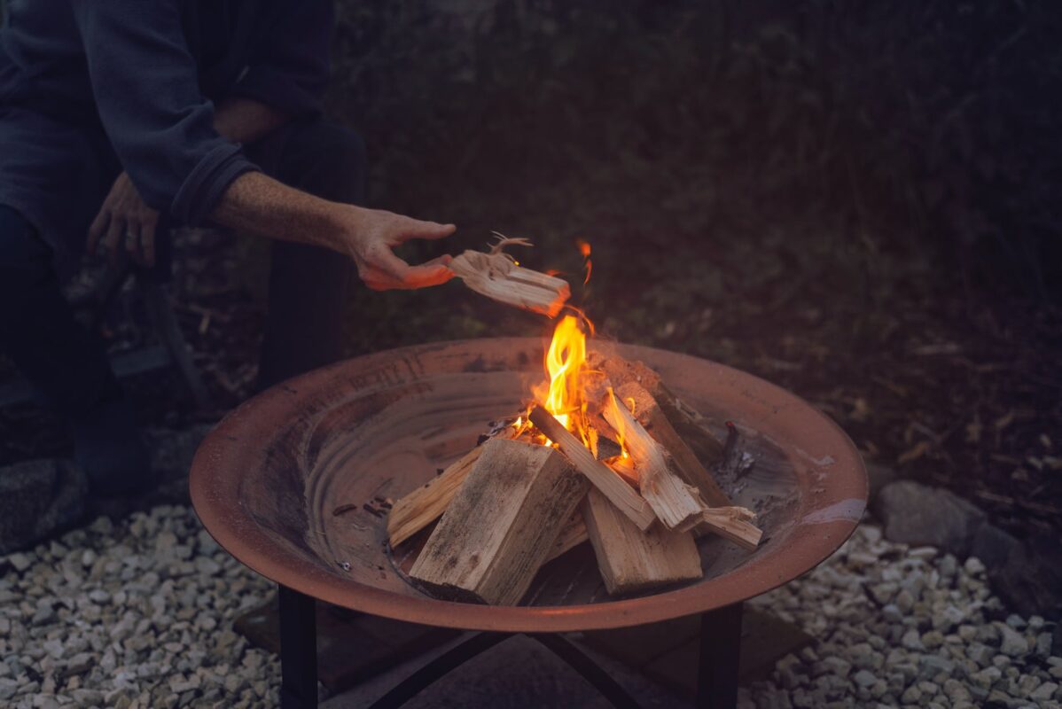 person holding brown wooden round tray with fire